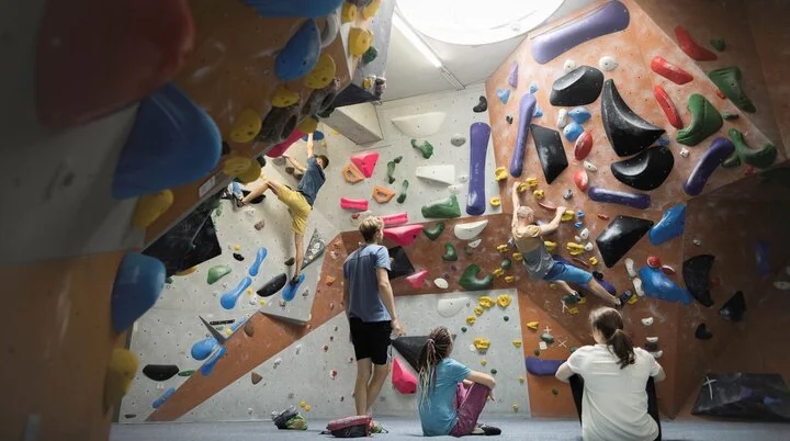 In der Boulderhalle: Ansicht einer Boulderwand mit Sportlern | © DAV / Jens Klatt