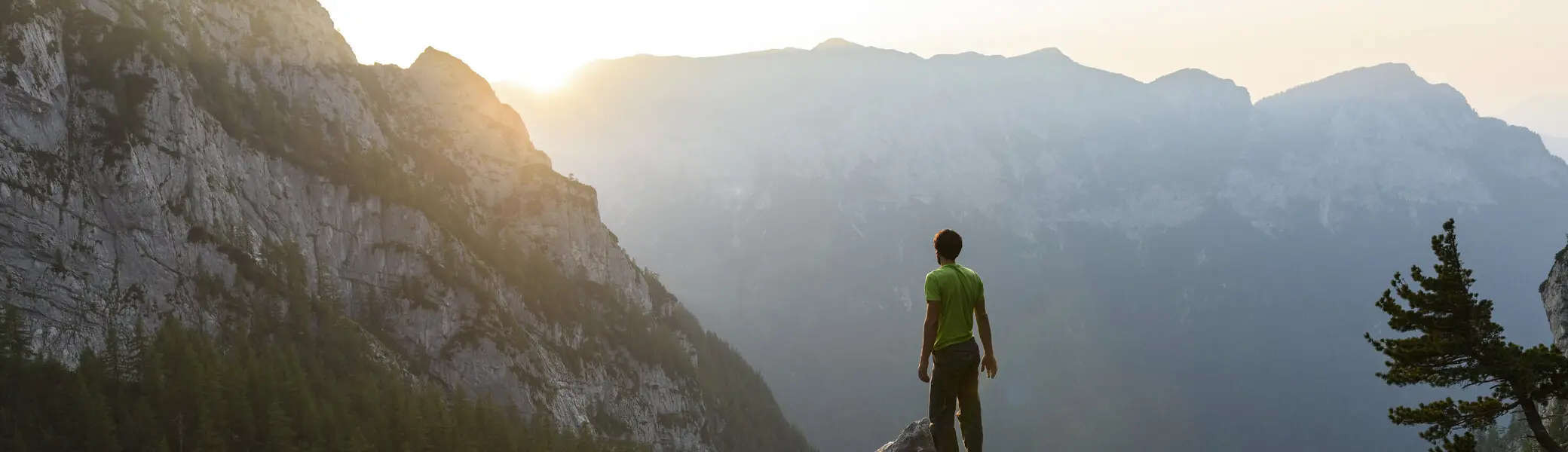 Ein Mann genießt auf einem Felsen den Sonnenuntergang | © DAV/Wolfgang Ehn